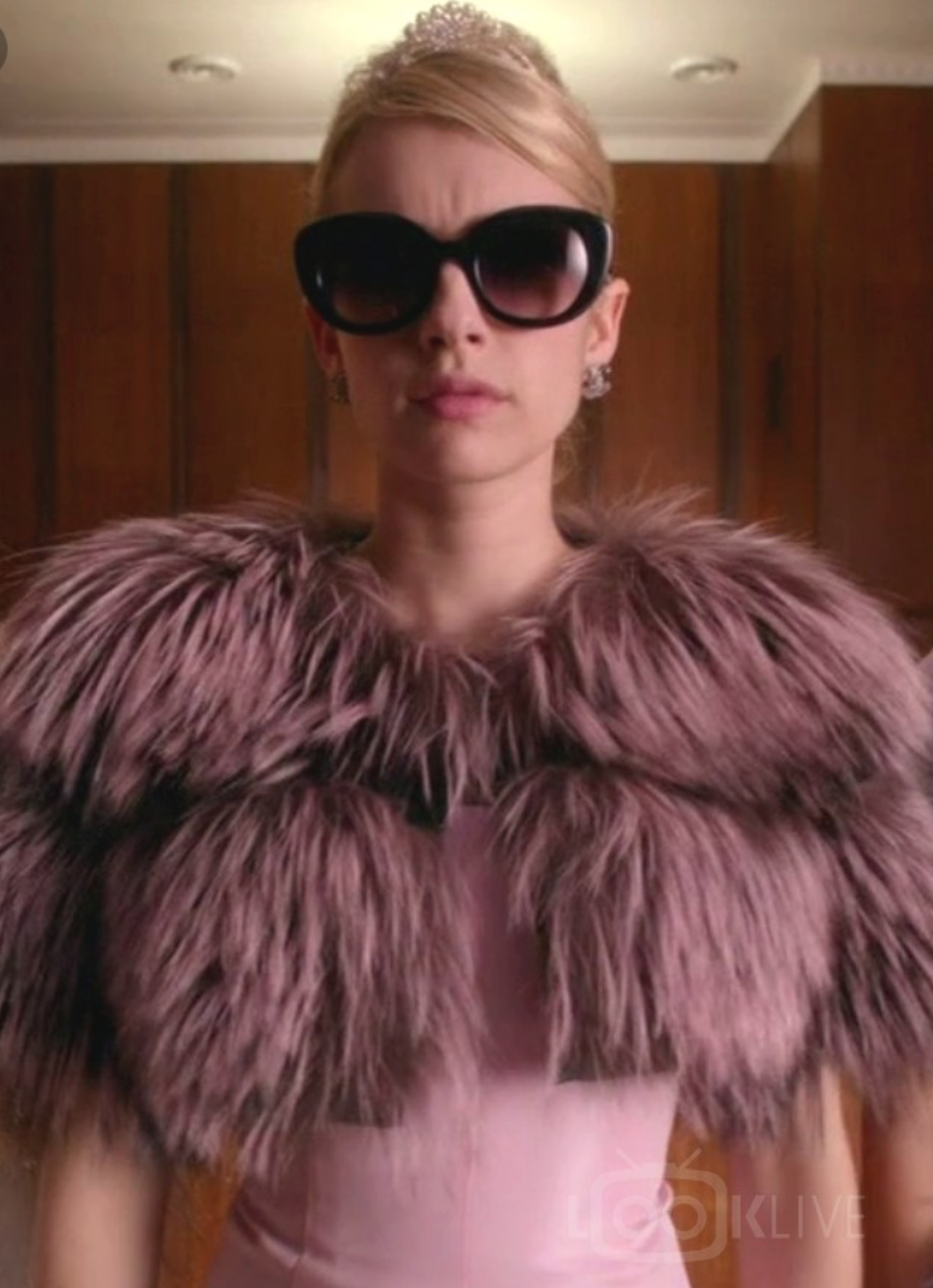 Emma Roberts wearing a pink dress with a fur shrug by Lilly e Violetta in fox and sunglasses.